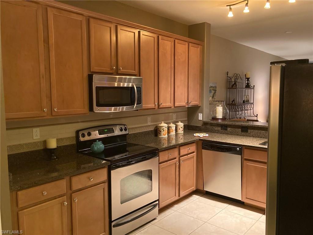 21334 Bella Terra Boulevard Estero, FL 33928 - Photo 12 of 30 a kitchen with stainless steel appliances granite countertop a stove a sink and a microwave