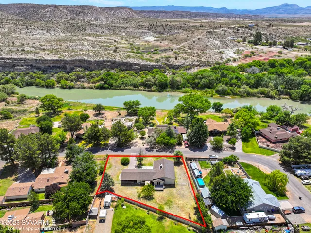 an aerial view of residential houses with outdoor space and lake view