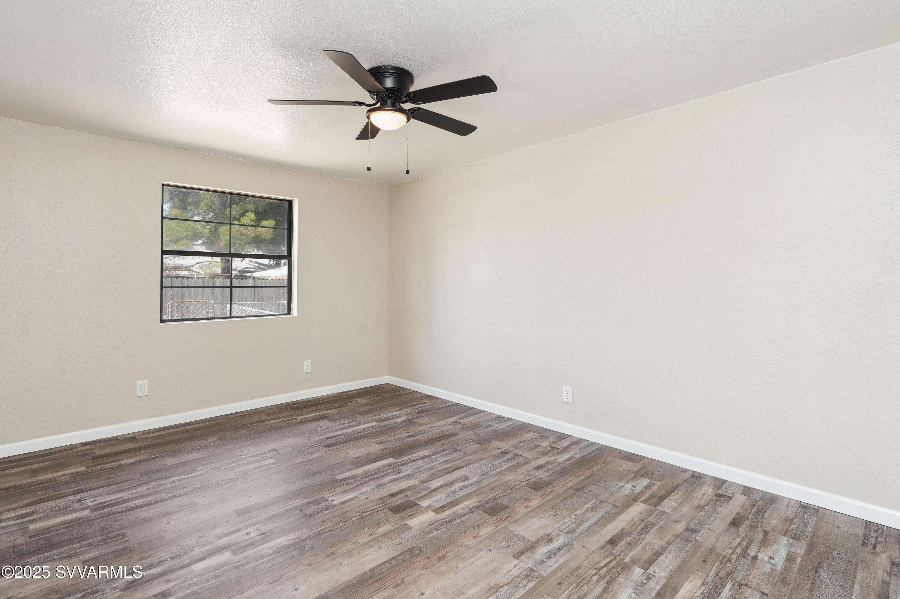248 South River Cave Road Camp Verde, AZ 86322 - Photo 20 of 36 an empty room with wooden floor ceiling fan and windows