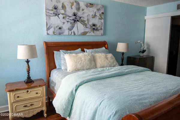 a bedroom with a bed and a lamp on dresser