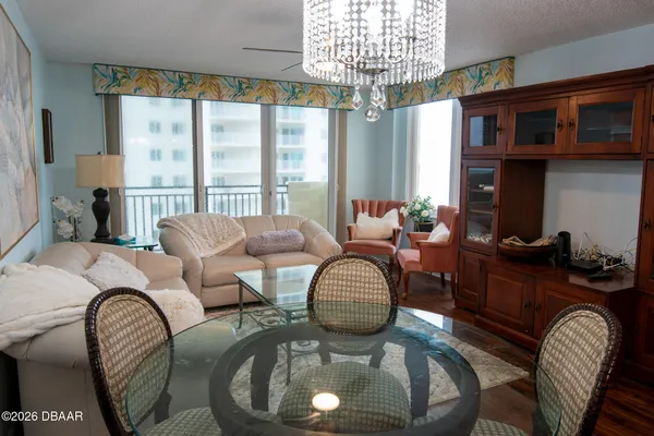 a living room with furniture a chandelier and a large window