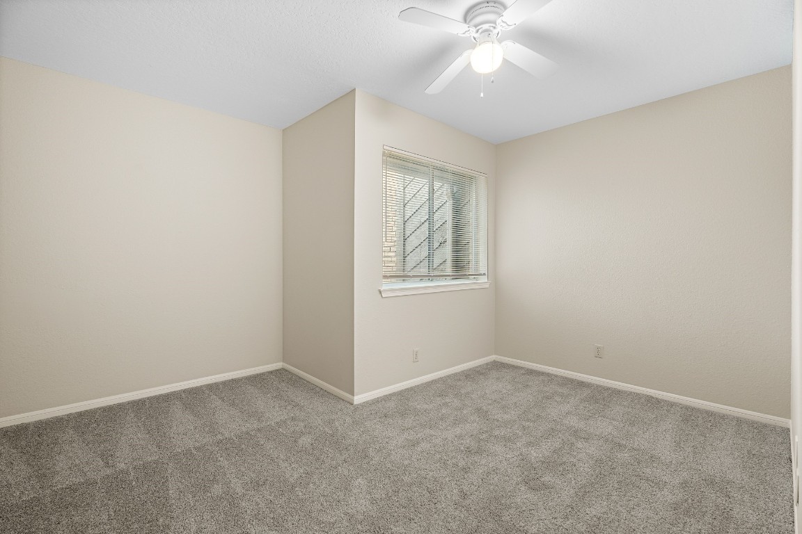 304 East Adoue Street Alvin, TX 77511 - Photo 9 of 12 an empty room with windows and fan