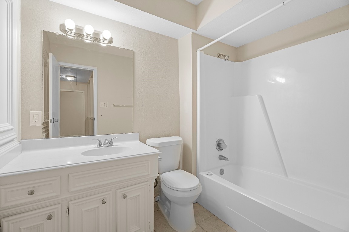 304 East Adoue Street Alvin, TX 77511 - Photo 10 of 12 a bathroom with a sink a toilet and shower