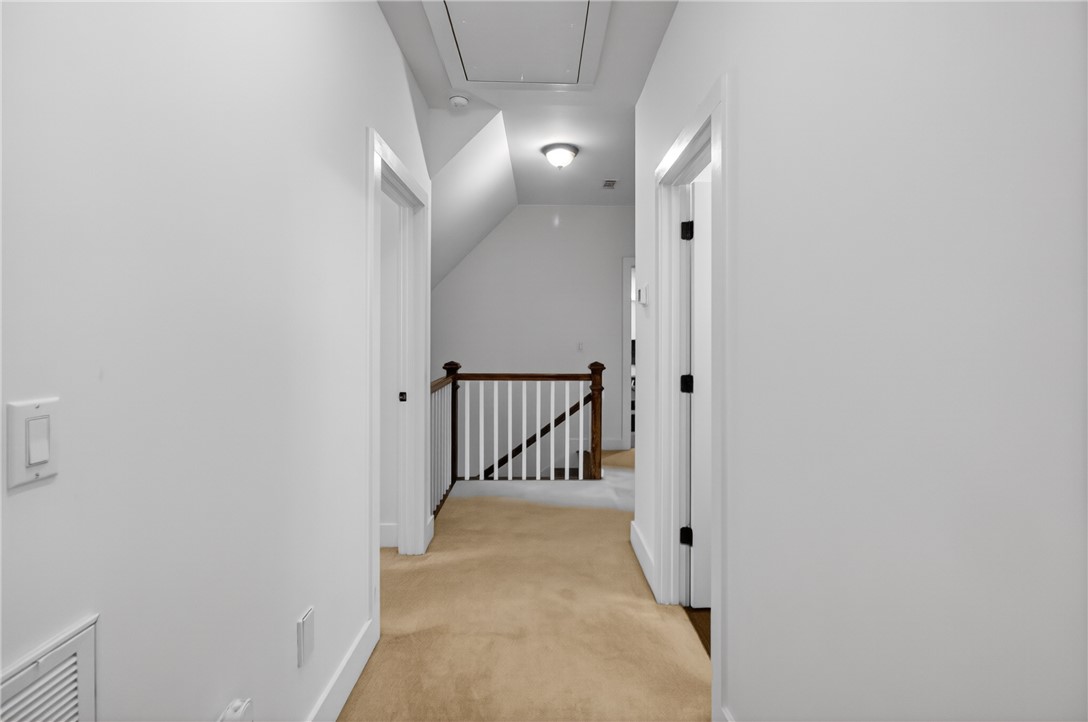 1504 Double Springs Road Townville, SC 29689 - Photo 25 of 41 This hallway features a staircase with wood and white railings and warm carpeted flooring.