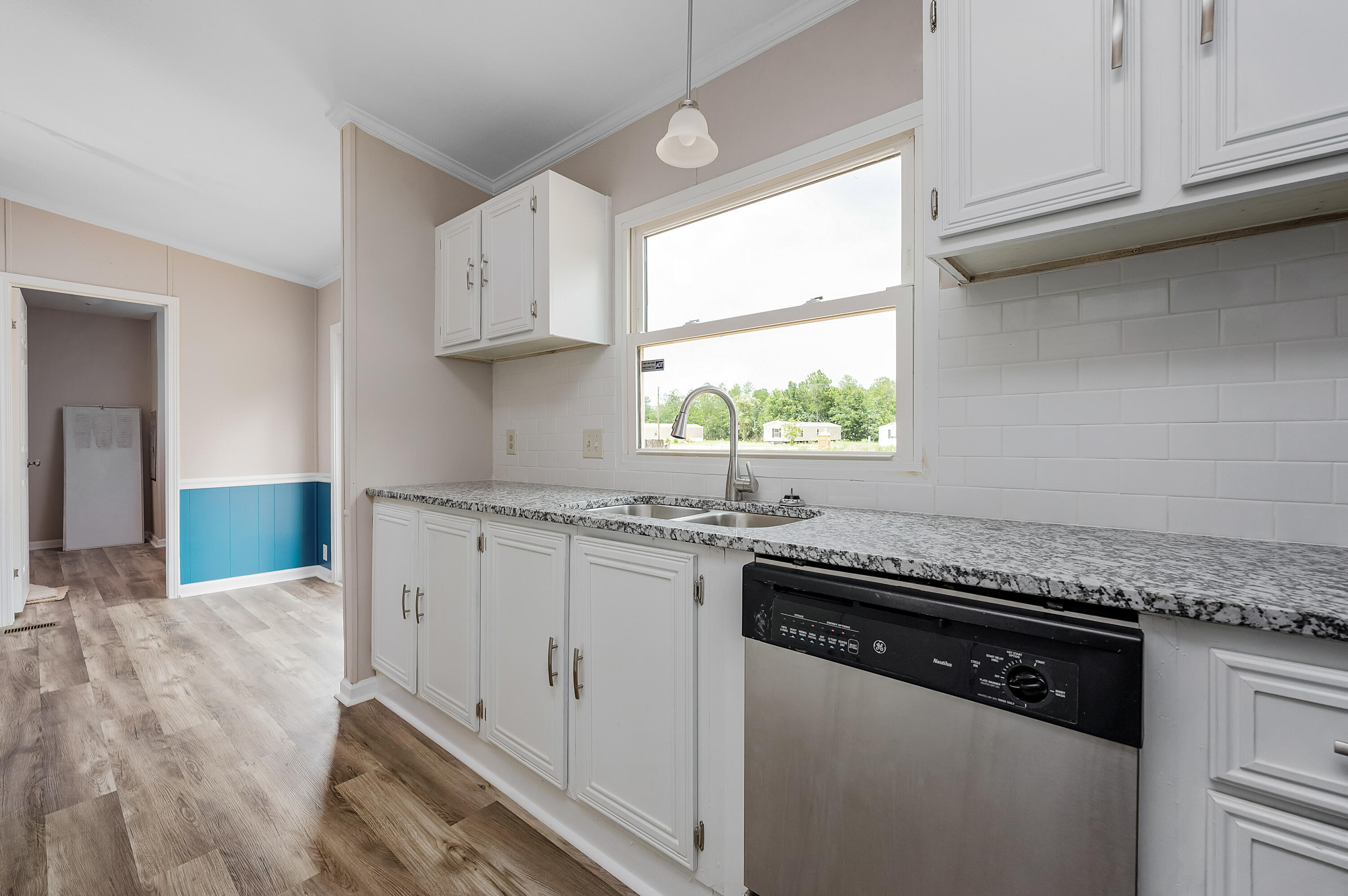 4625 Canary Way Crestview, FL 32539 - Photo 12 of 40 a kitchen with granite countertop a sink stainless steel appliances white cabinets and a window