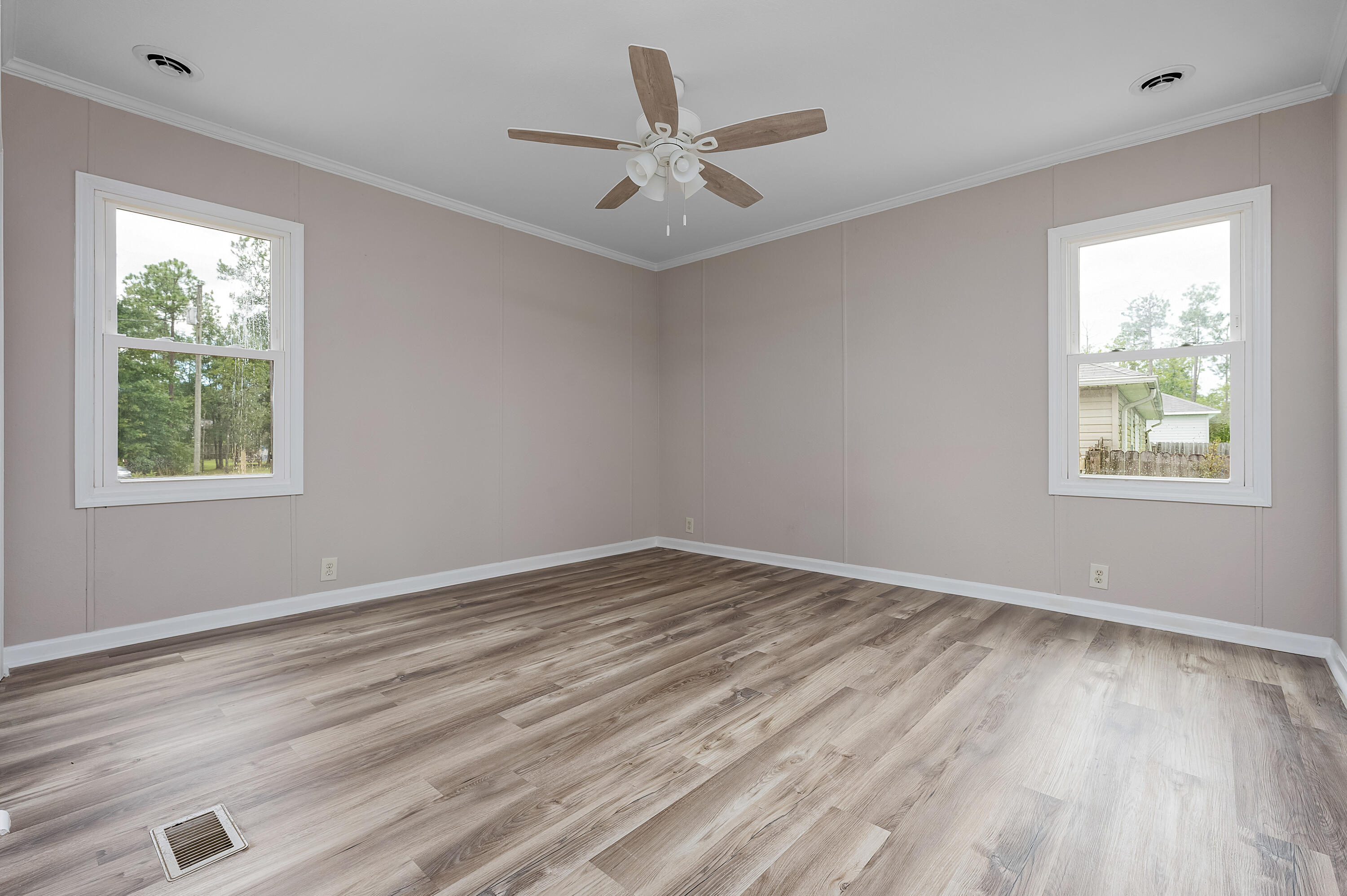 4625 Canary Way Crestview, FL 32539 - Photo 18 of 40 a view of an empty room with wooden floor and a window
