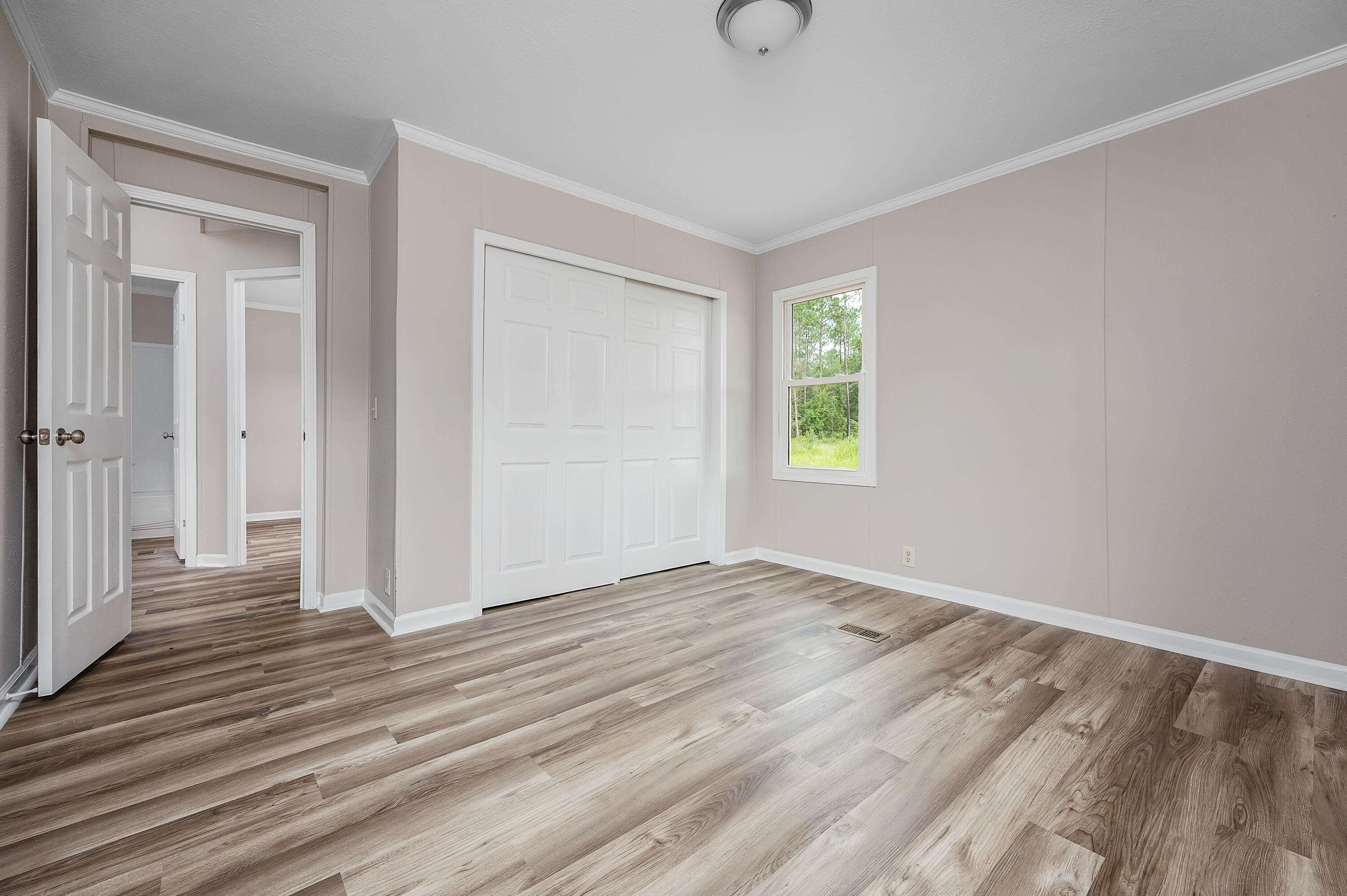 4625 Canary Way Crestview, FL 32539 - Photo 26 of 40 a view of an empty room with wooden floor and a window