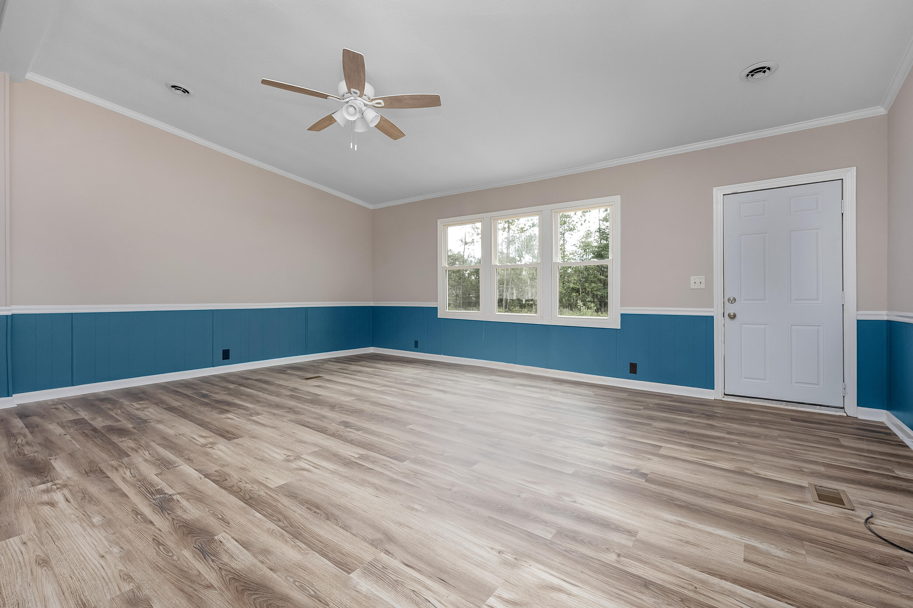 4625 Canary Way Crestview, FL 32539 - Photo 4 of 40 a view of an empty room with wooden floor and a window