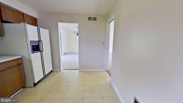 a view of a hallway with a refrigerator