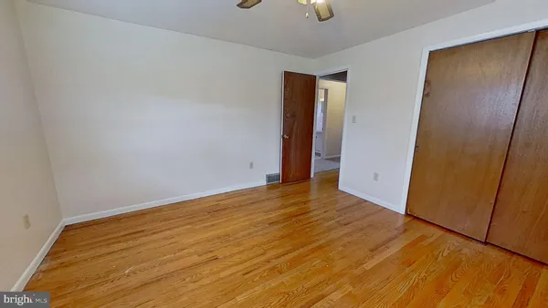 a view of empty room with wooden floor