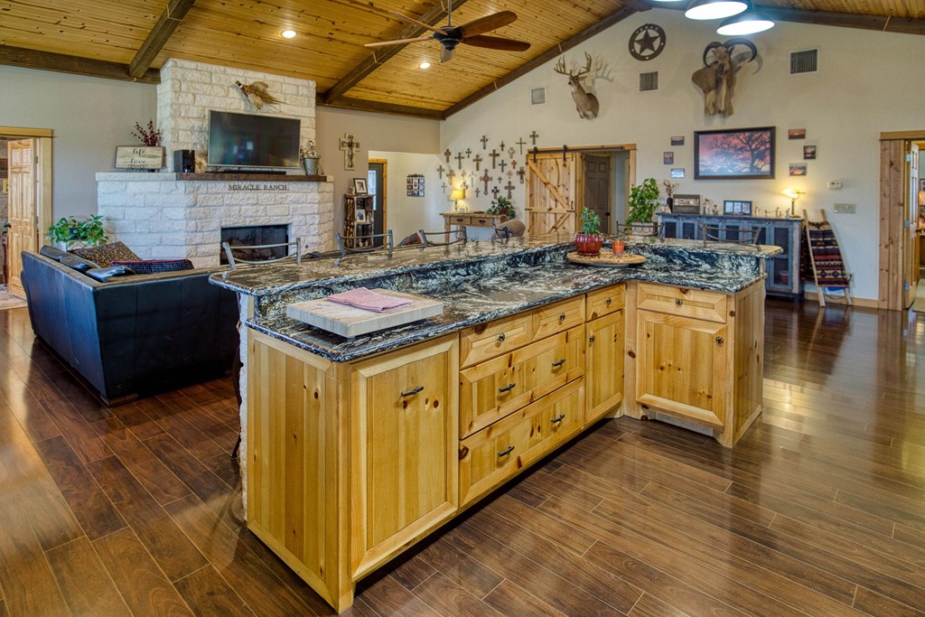 6446 Blackjack Road Fredonia, TX 76842 - Photo 25 of 52 a kitchen with stainless steel appliances granite countertop a stove and a wooden cabinets