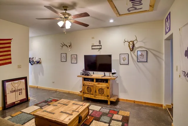 a living room with furniture a flat screen tv and a window