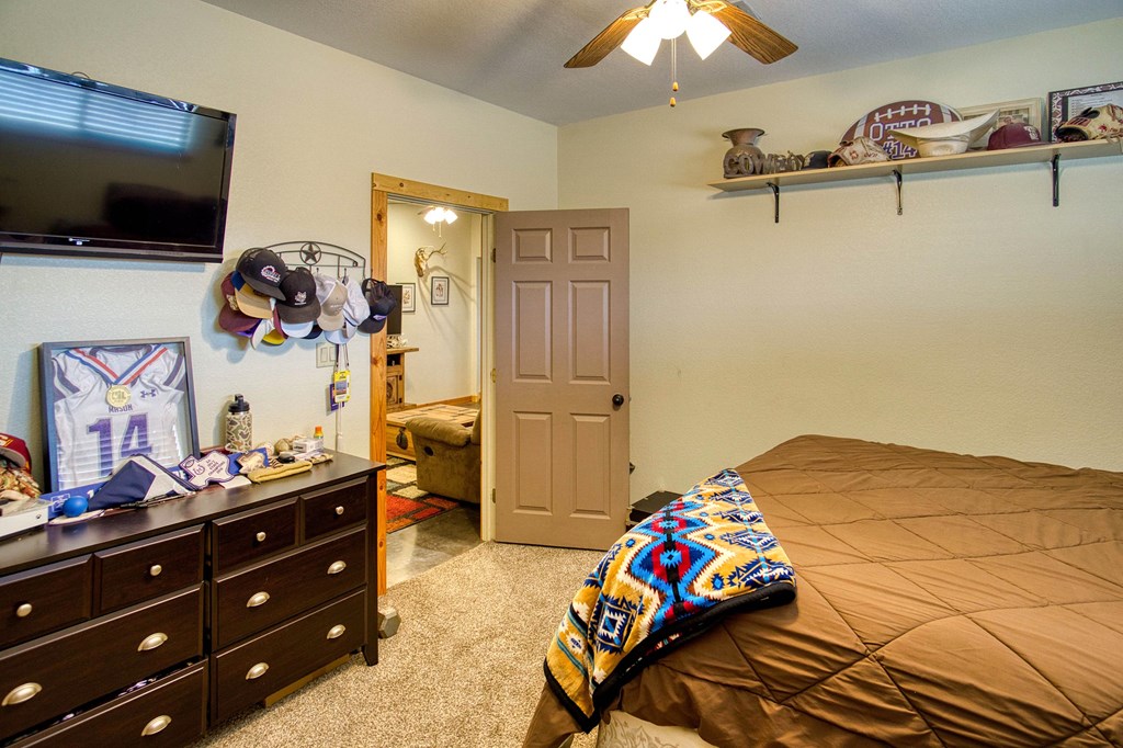 6446 Blackjack Road Fredonia, TX 76842 - Photo 37 of 52 a bedroom with a bed and a flat tv screen on dresser