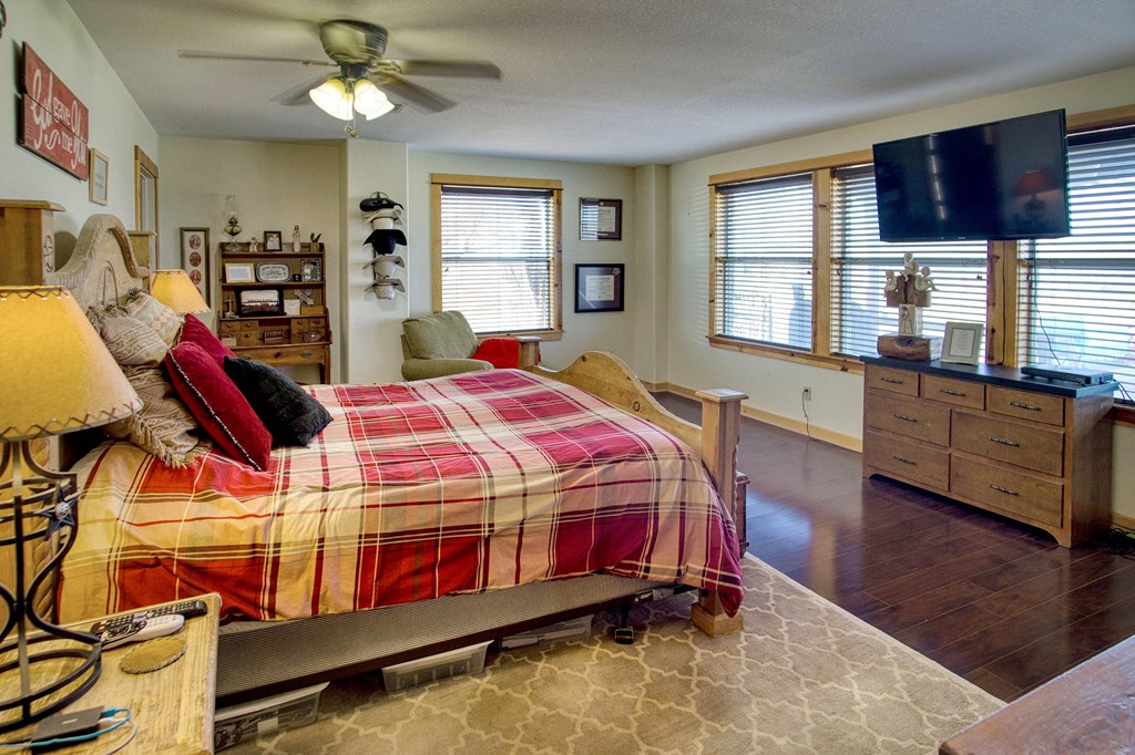 6446 Blackjack Road Fredonia, TX 76842 - Photo 40 of 52 a bedroom with a bed a dresser next to a window with wooden floor
