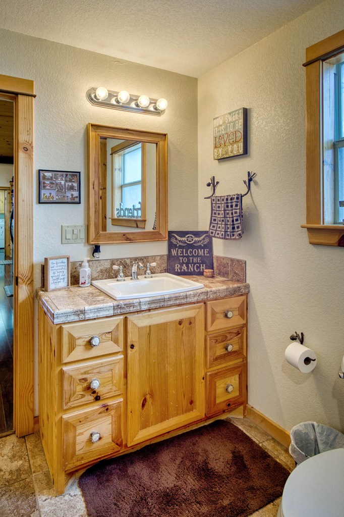 6446 Blackjack Road Fredonia, TX 76842 - Photo 49 of 52 a spacious bathroom with a granite countertop sink and a mirror
