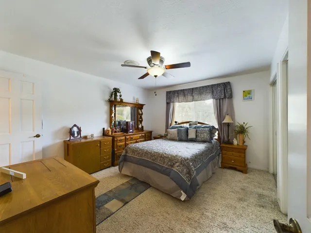 a bedroom with a bed and ceiling fan