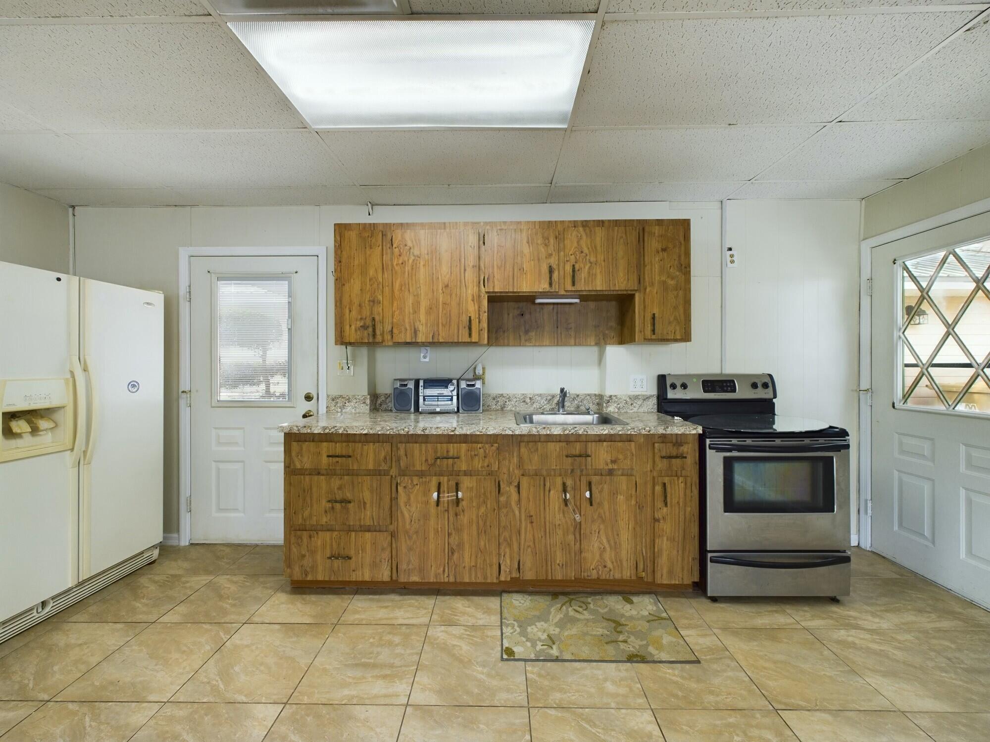 1517 Southwest 7th Avenue Okeechobee, FL 34974 - Photo 31 of 51 a kitchen with stainless steel appliances granite countertop a stove a sink and a refrigerator