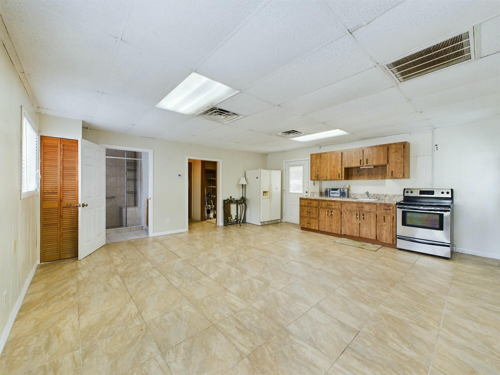 1517 Southwest 7th Avenue Okeechobee, FL 34974 - Photo 32 of 51 a large kitchen with stainless steel appliances kitchen island granite countertop a stove and a refrigerator with cabinets