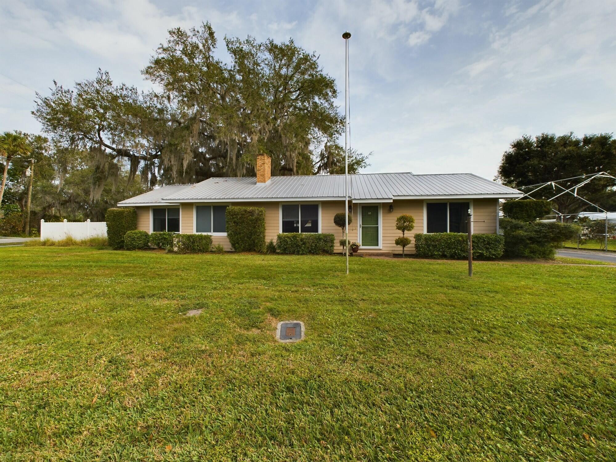 1517 Southwest 7th Avenue Okeechobee, FL 34974 - Photo 48 of 51 a front view of a house with a yard table and chairs