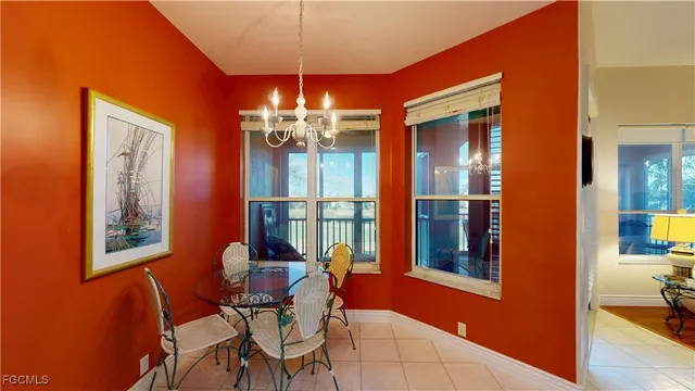 a dining room with chandelier and wooden floor