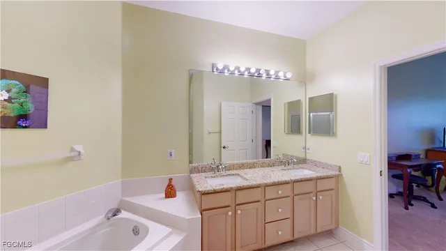 a bathroom with a tub sink and mirror