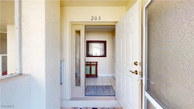 a view of a hallway view with wooden floor and a living room
