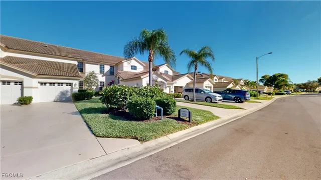 a front view of a house with a yard and potted plants