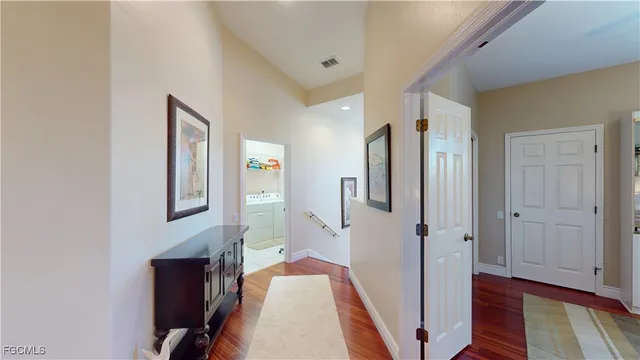 a view of a hallway with closet and wooden floor