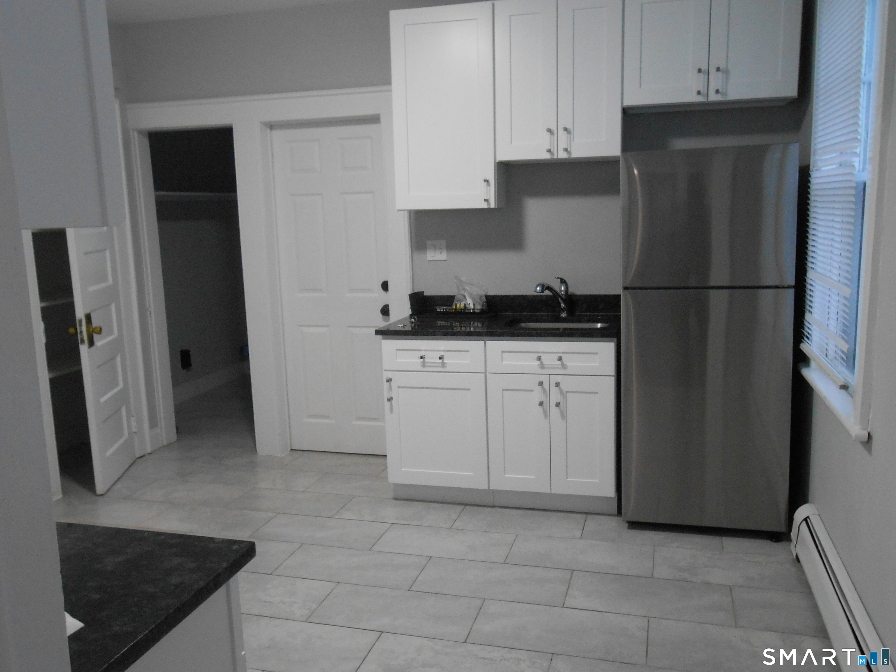 254 Wayne Street Bridgeport, CT 06606 - Photo 22 of 25 a kitchen with granite countertop a refrigerator and a stove top oven