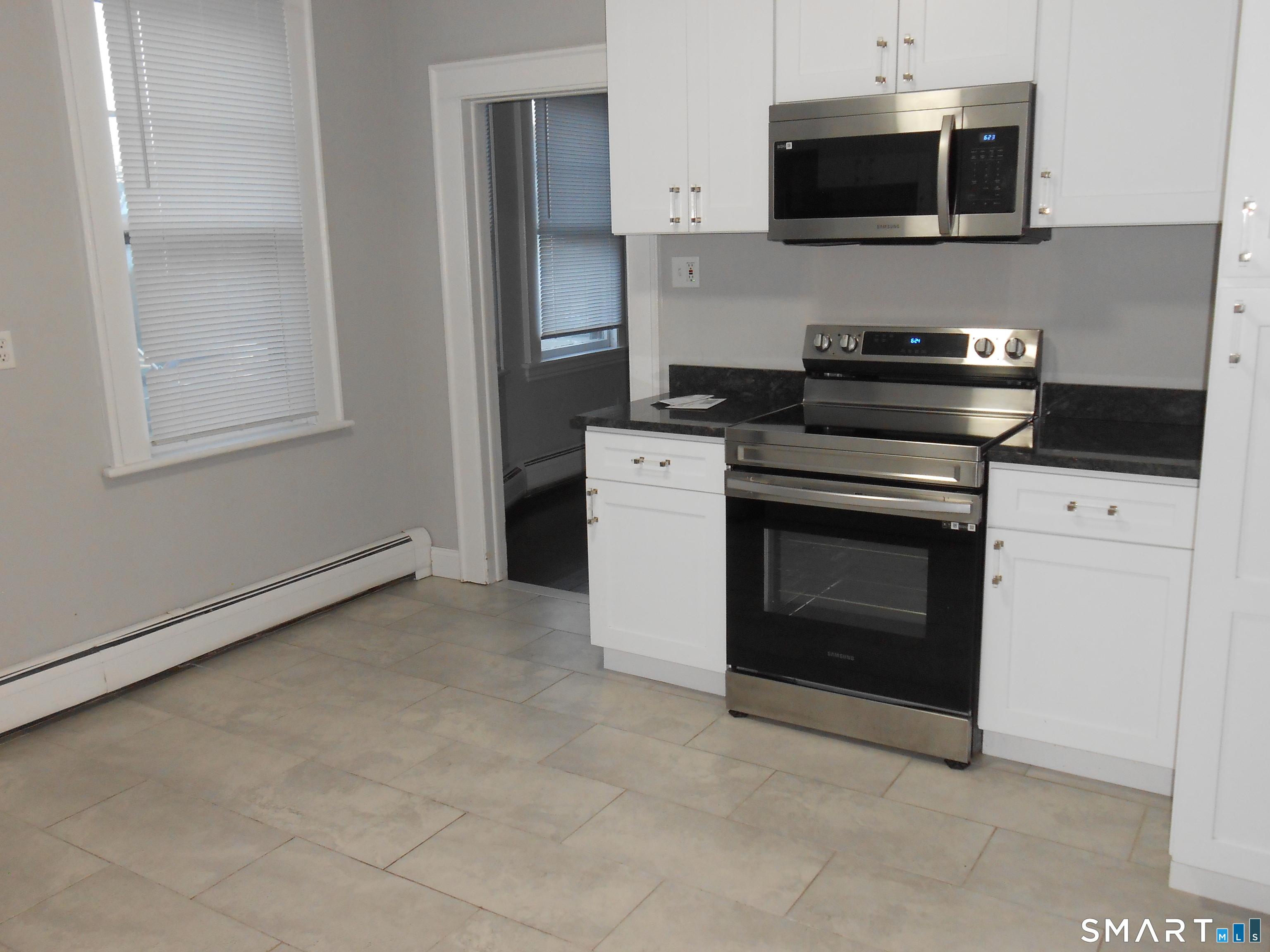 254 Wayne Street Bridgeport, CT 06606 - Photo 6 of 25 a kitchen with stainless steel appliances a stove a microwave and cabinets
