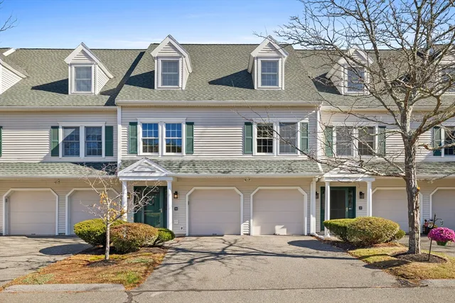 a front view of a house with yard and parking