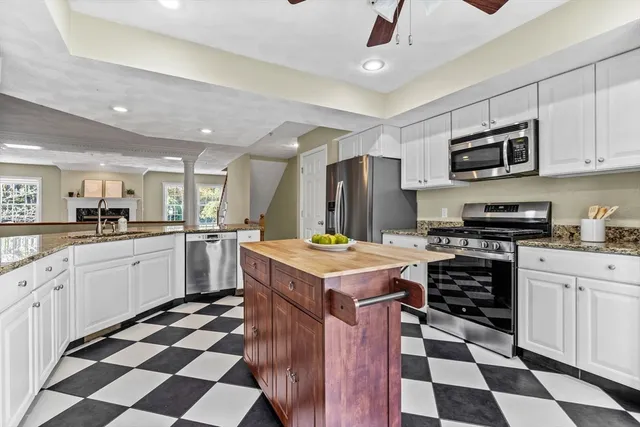 a kitchen with stainless steel appliances granite countertop a stove a sink and a refrigerator