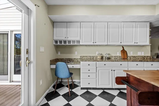 a kitchen with granite countertop white cabinets and appliances