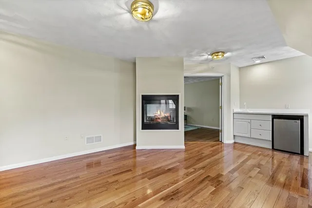 a view of an empty room and window with wooden floor