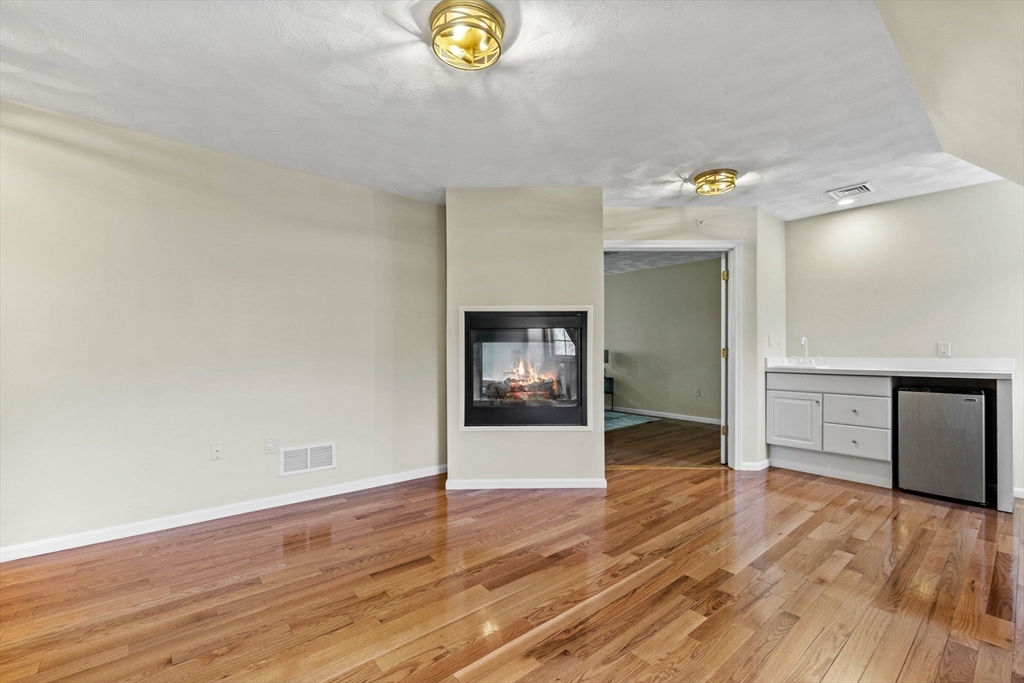30 Maytum Way, Unit 30 Middleton, MA 01949 - Photo 20 of 42 a view of an empty room and window with wooden floor
