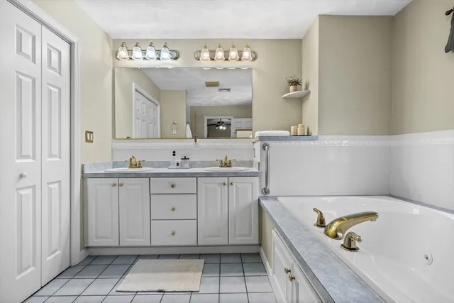 a spacious bathroom with a tub sink and mirror