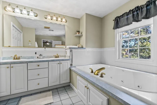 a bathroom with a tub sink and mirror