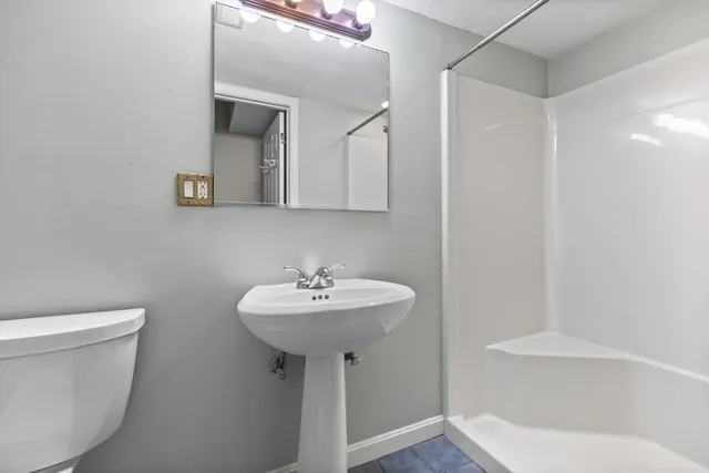 a bathroom with a sink toilet and mirror