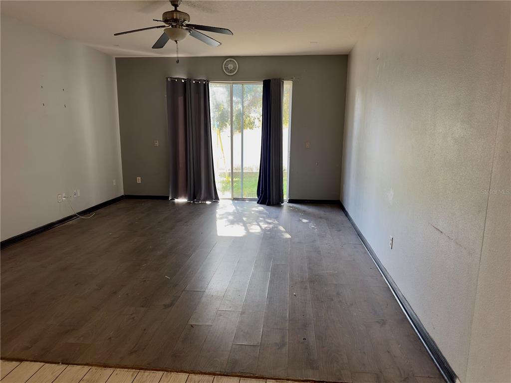 403 Thicket Crest Road Seffner, FL 33584 - Photo 12 of 28 an empty room with wooden floor and windows