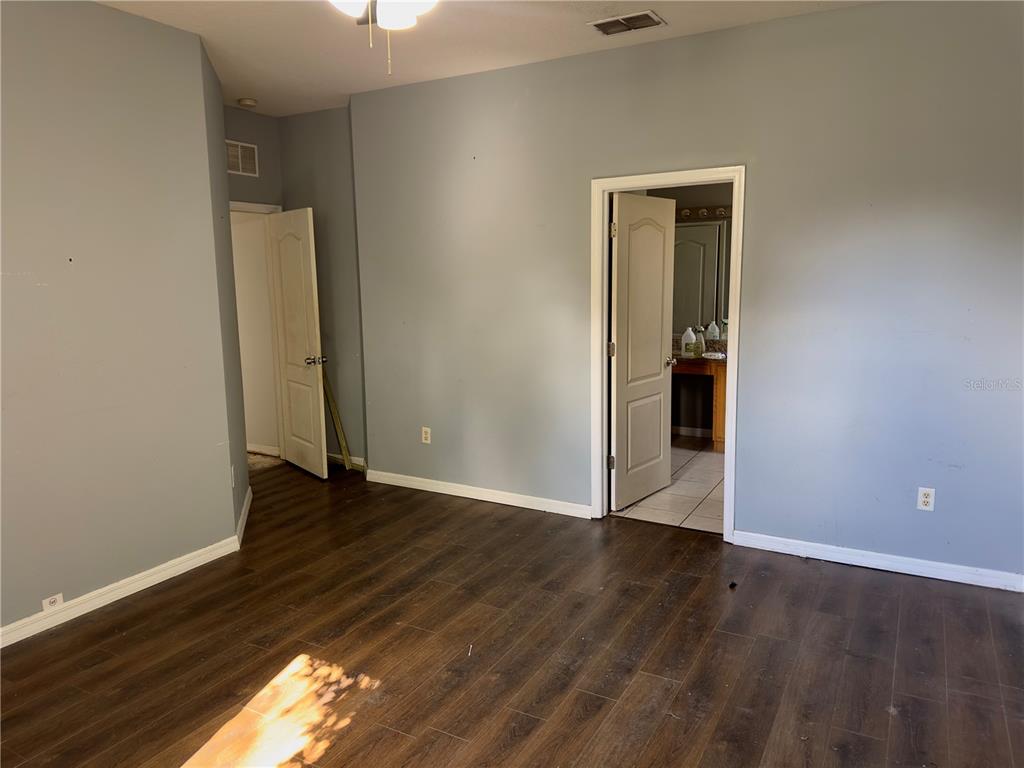 403 Thicket Crest Road Seffner, FL 33584 - Photo 23 of 28 a view of an empty room with wooden floor and a window