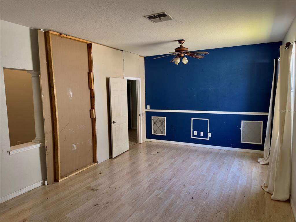 403 Thicket Crest Road Seffner, FL 33584 - Photo 6 of 28 an empty room with wooden floor and cabinet