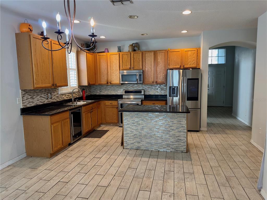 403 Thicket Crest Road Seffner, FL 33584 - Photo 8 of 28 a kitchen with stainless steel appliances granite countertop a stove a sink and a refrigerator