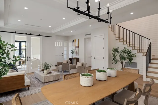 a kitchen with stainless steel appliances kitchen island granite countertop a table chairs sink and cabinets