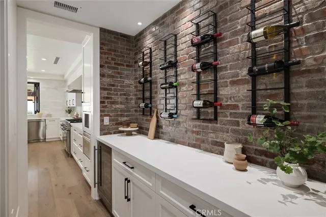 a kitchen with stainless steel appliances kitchen island granite countertop a table chairs sink and cabinets