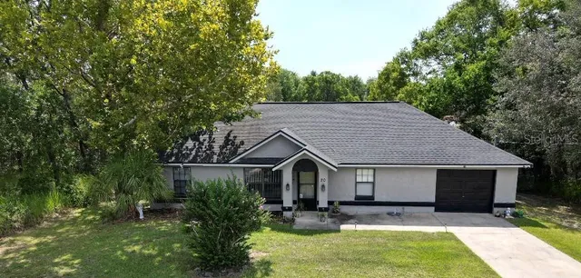 a view of a house with backyard and sitting area