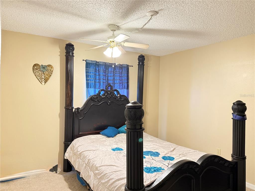 20 Cedar Road Ocala, FL 34472 - Photo 11 of 28 a bedroom with a bed and a chandelier