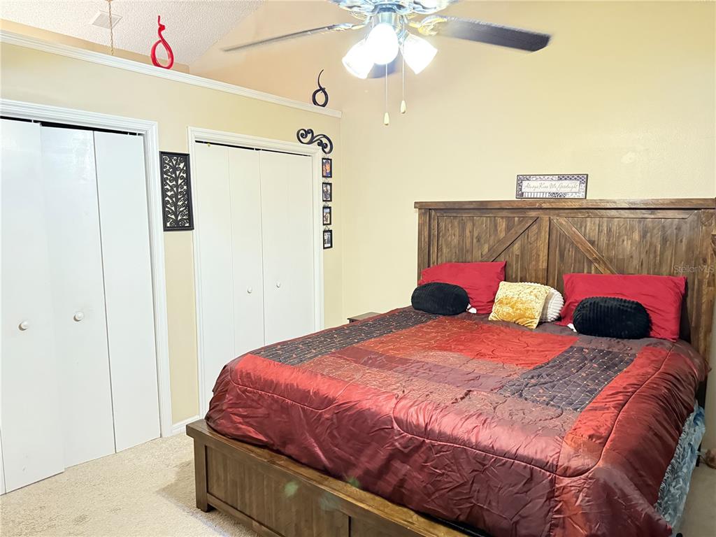 20 Cedar Road Ocala, FL 34472 - Photo 13 of 28 a bedroom with a bed and a chandelier