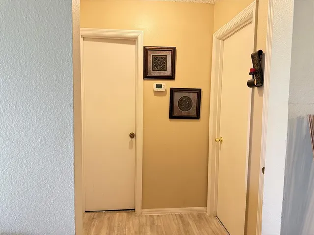 a view of a hallway with wooden floor and a cabinet