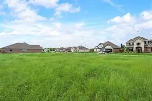 a view of a house with a big yard and large trees