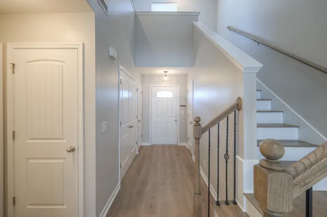 a view of a hallway with wooden floor and staircase
